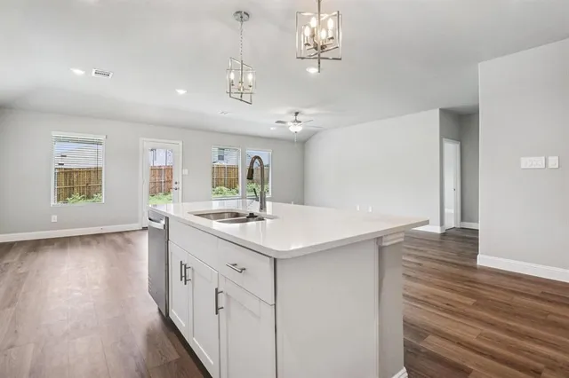 a kitchen with a sink and wooden floor
