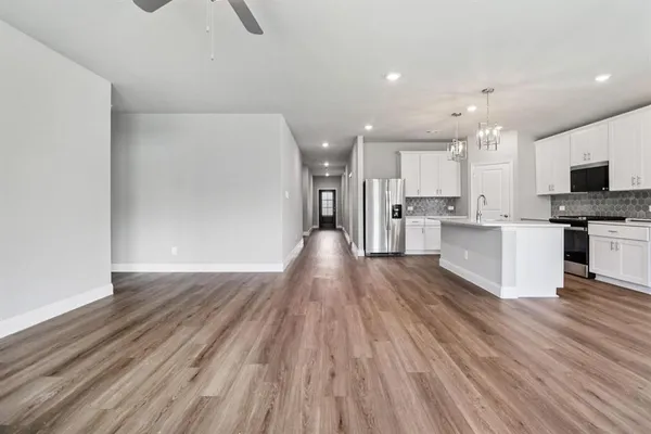 a view of kitchen view wooden floors appliances and cabinets