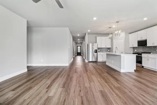 a view of kitchen view wooden floors appliances and cabinets