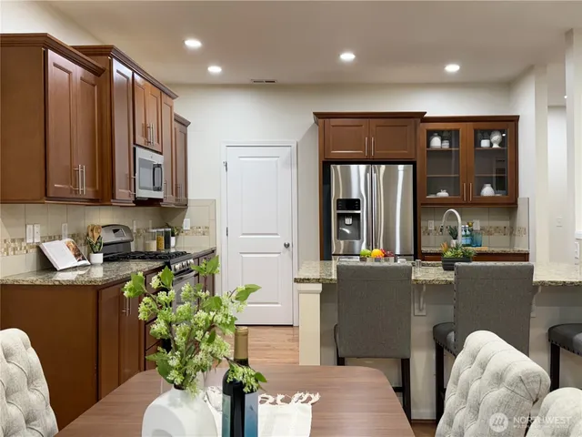 a kitchen with stainless steel appliances granite countertop a sink refrigerator and microwave