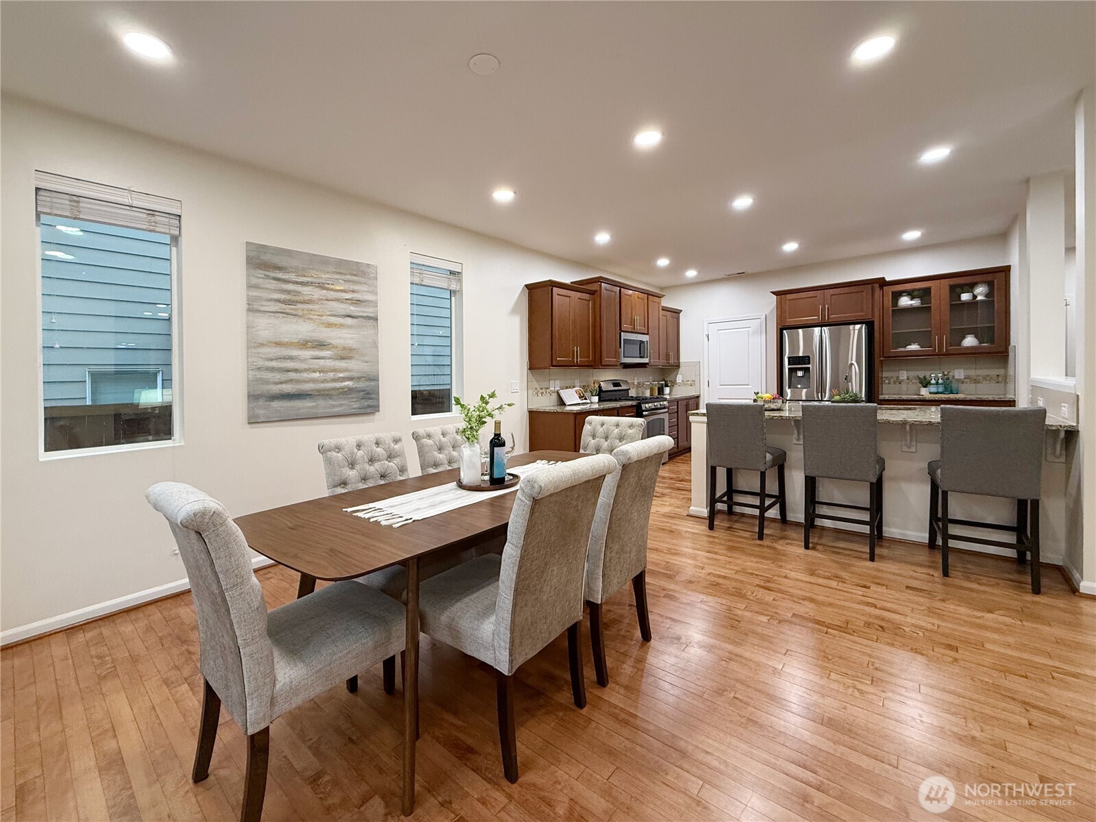 3918 177th Street Southeast Bothell, WA 98012 - Photo 10 of 39 a dining room with stainless steel appliances kitchen island granite countertop a dining table chairs and a refrigerator