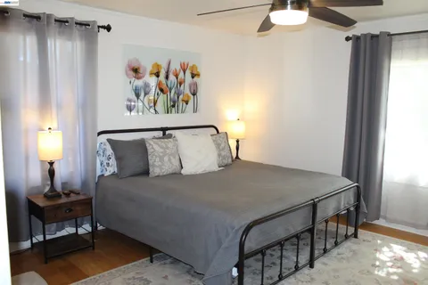 a bed room with a bed and a painting on the wall