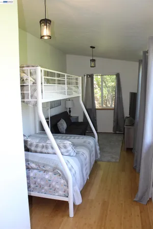 a bedroom with a bed and a wooden floor