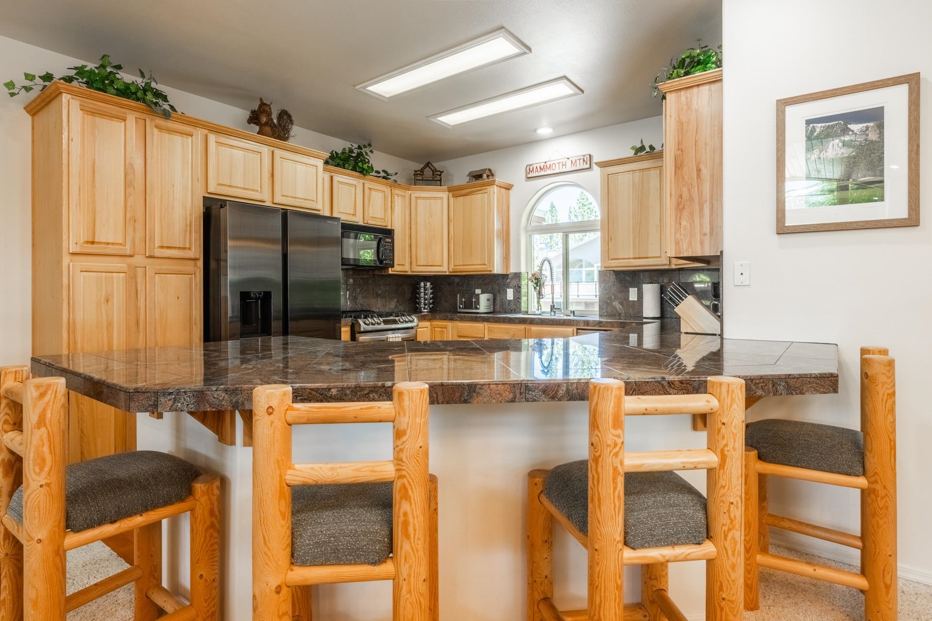 372 Wagon Wheel Road Mammoth Lakes, CA 93546 - Photo 12 of 50 a kitchen with stainless steel appliances kitchen island granite countertop dining table chairs and a large window