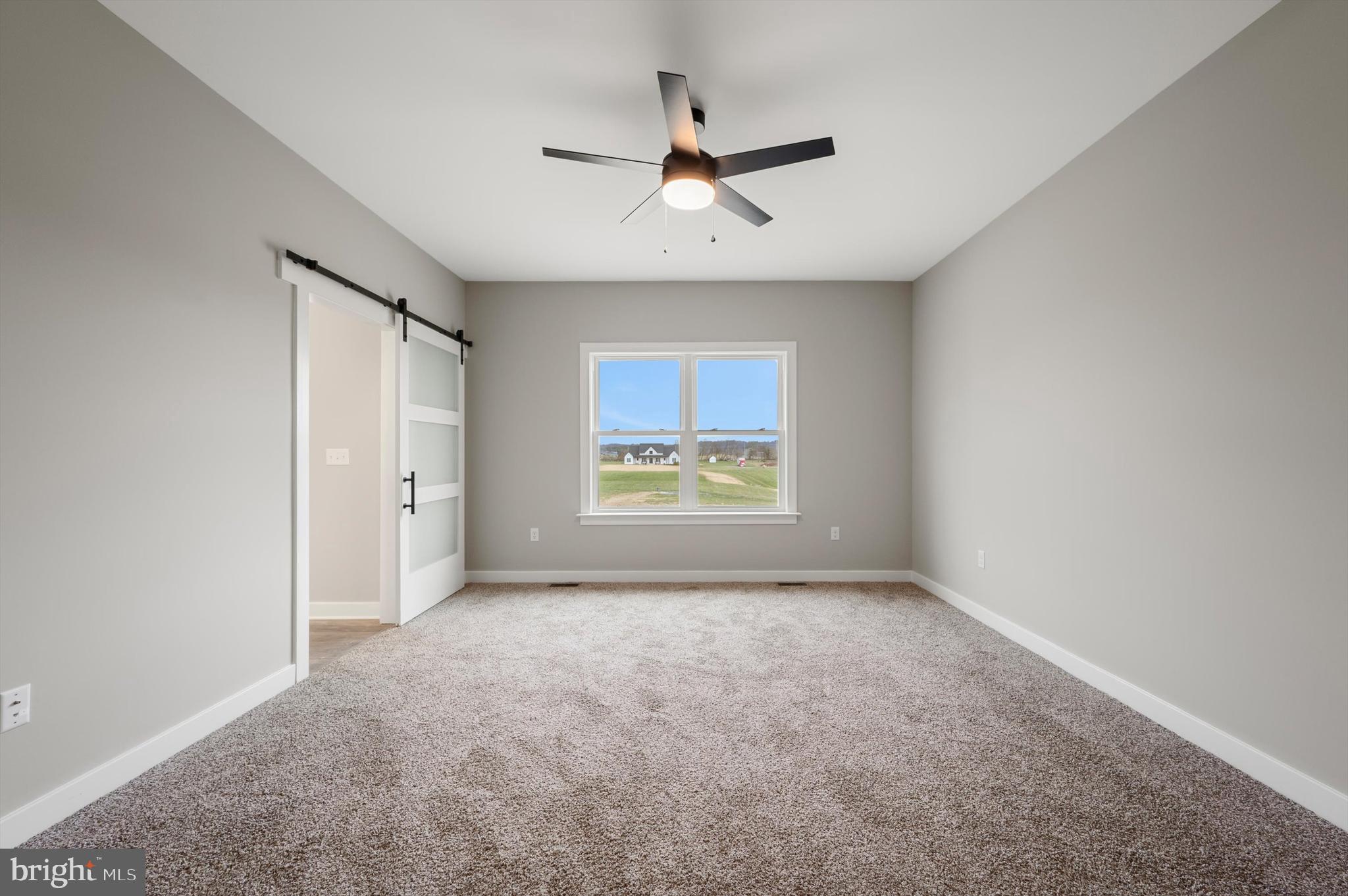 309 Gun Club Road Stephenson, VA 22656 - Photo 23 of 41 an empty room with windows and a ceiling fan