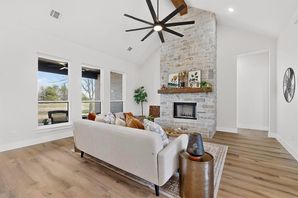 4961 County Road 1098 Celeste, TX 75423 - Photo 9 of 40 Living area with a ceiling fan, light wood-type flooring, and a stone fireplace