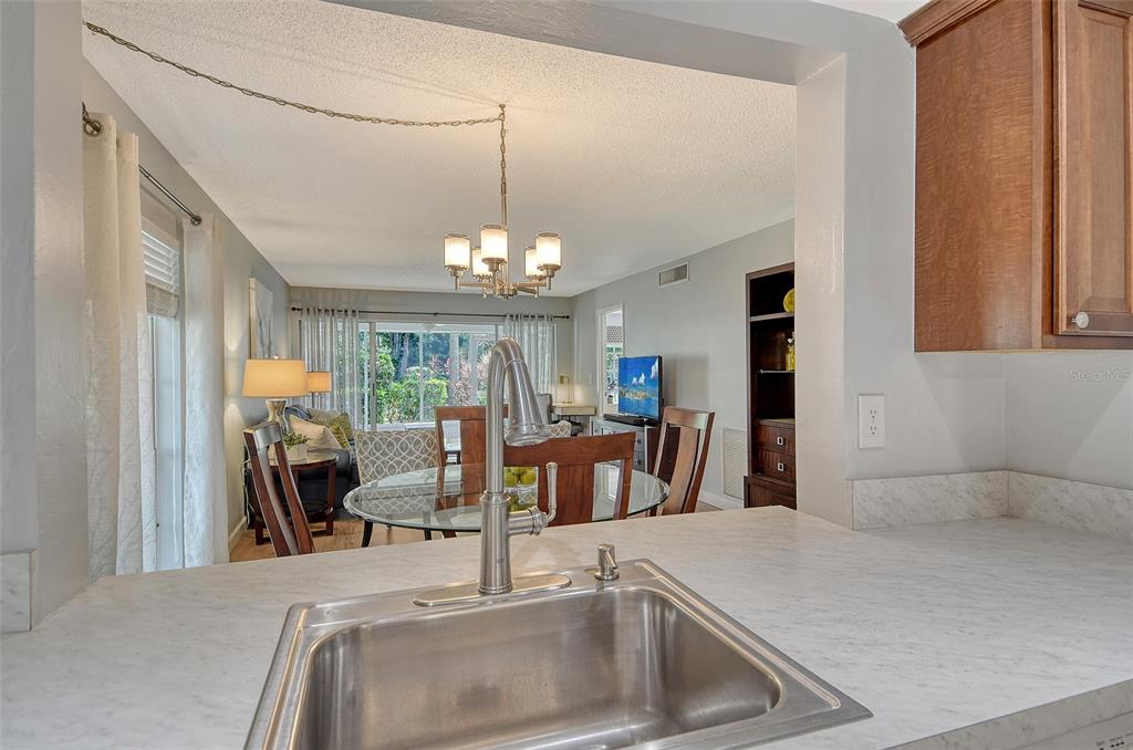 5246 Marsh Field Lane, Unit 1 Sarasota, FL 34235 - Photo 12 of 49 a view of a kitchen with a sink and chandelier