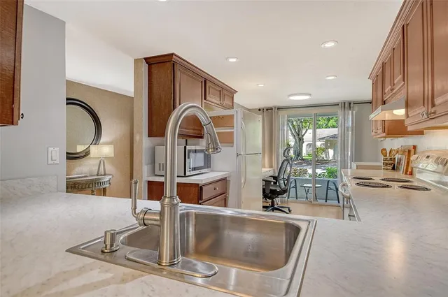 a kitchen with stainless steel appliances granite countertop a sink and a refrigerator
