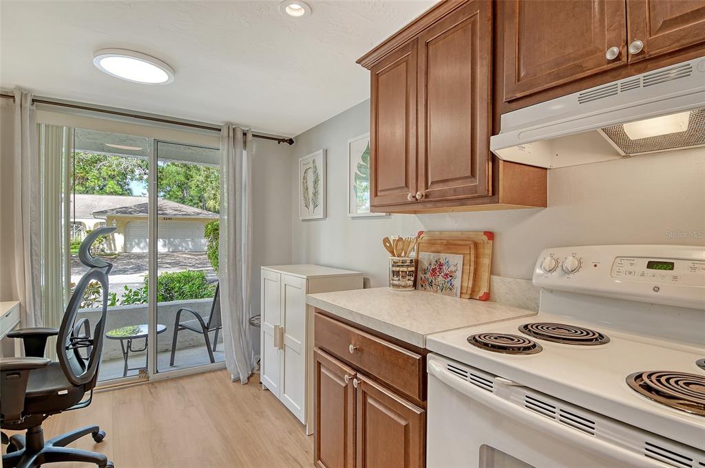 5246 Marsh Field Lane, Unit 1 Sarasota, FL 34235 - Photo 15 of 49 a kitchen with a stove a refrigerator and wooden cabinets