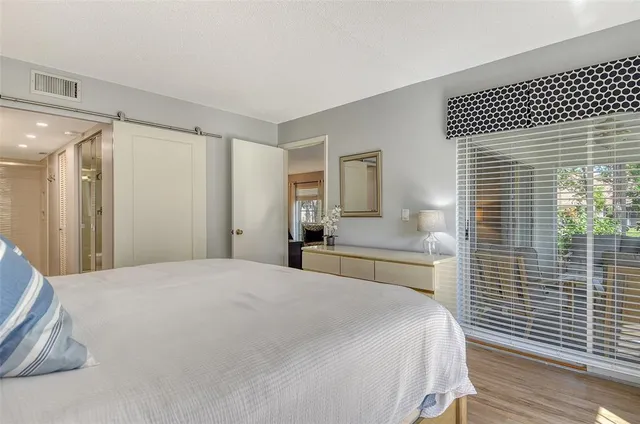 a spacious bedroom with a bed and a large mirror