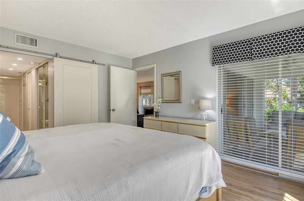 5246 Marsh Field Lane, Unit 1 Sarasota, FL 34235 - Photo 18 of 49 a spacious bedroom with a bed and a large mirror