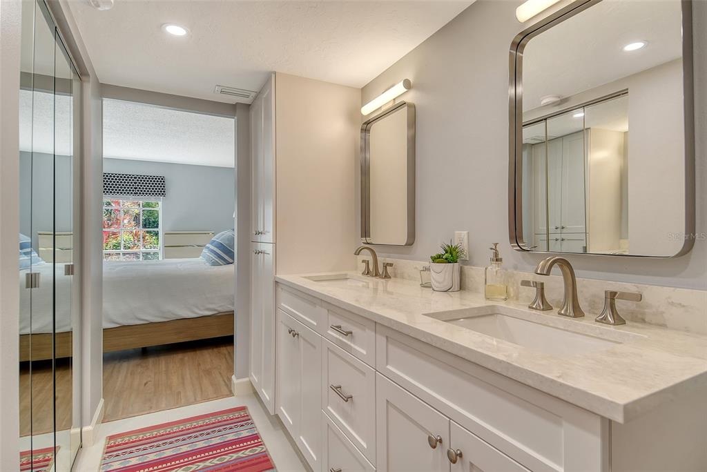 5246 Marsh Field Lane, Unit 1 Sarasota, FL 34235 - Photo 22 of 49 a en suite bathroom with a double vanity sink and mirror