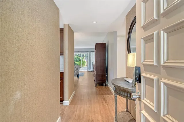 a view of a hallway with furniture and wooden floor