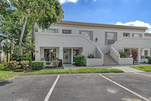 a front view of a house with a yard and trees