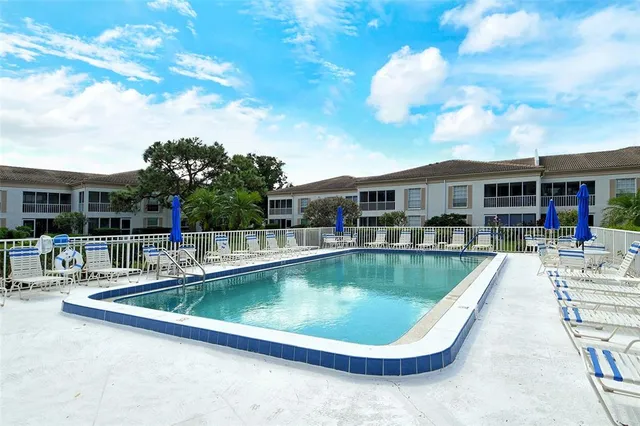 swimming pool view with a seating space and a garden view