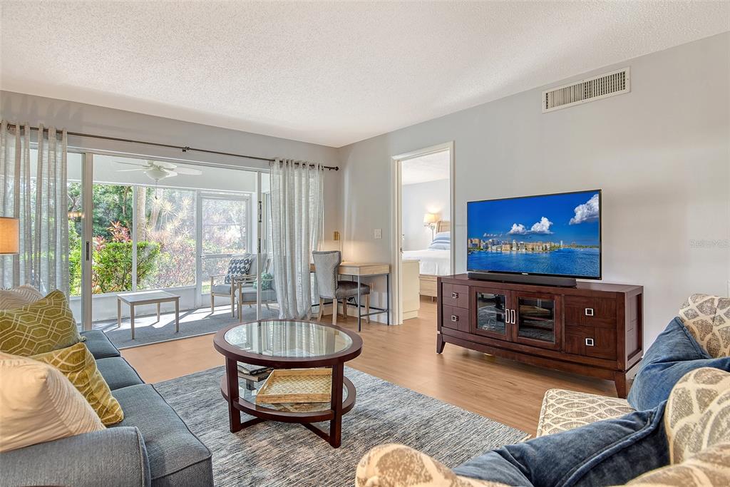 5246 Marsh Field Lane, Unit 1 Sarasota, FL 34235 - Photo 5 of 49 a living room with furniture a flat screen tv and a large window