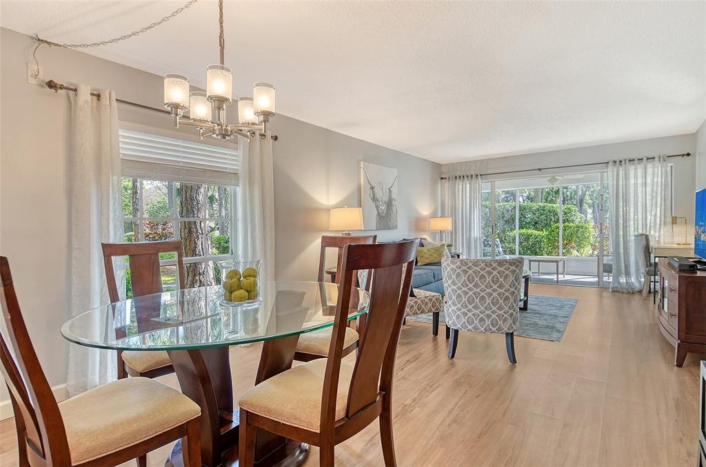 5246 Marsh Field Lane, Unit 1 Sarasota, FL 34235 - Photo 7 of 49 a dining room with furniture a chandelier and wooden floor