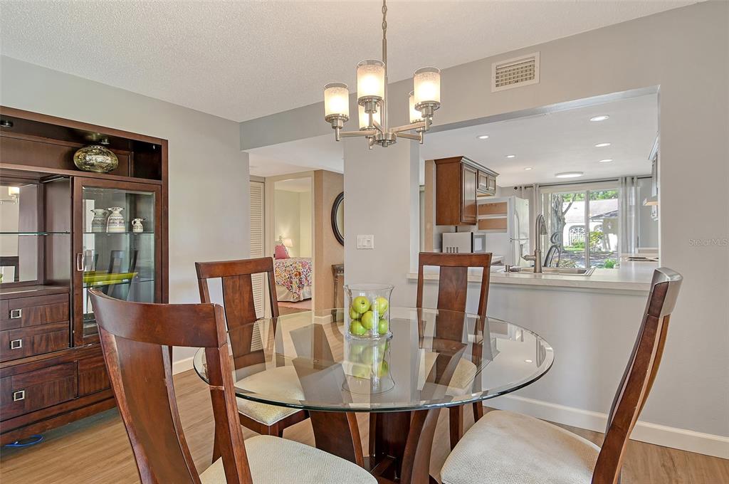 5246 Marsh Field Lane, Unit 1 Sarasota, FL 34235 - Photo 9 of 49 a view of a dining room with furniture a chandelier and wooden floor