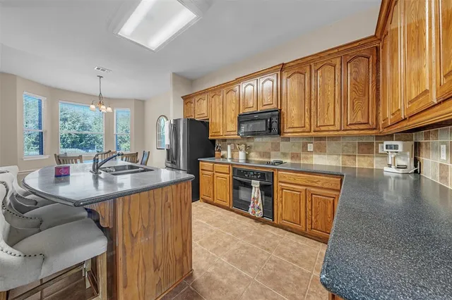 a kitchen with stainless steel appliances granite countertop a sink stove and cabinets