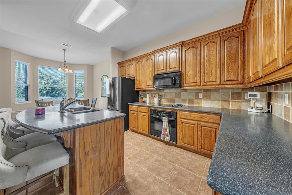 437 Rusty Run Drive Midlothian, TX 76065 - Photo 12 of 40 a kitchen with stainless steel appliances granite countertop a sink stove and cabinets