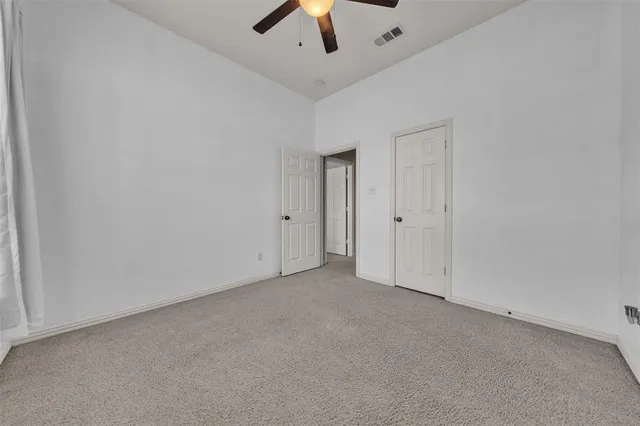 an empty room with chandelier fan