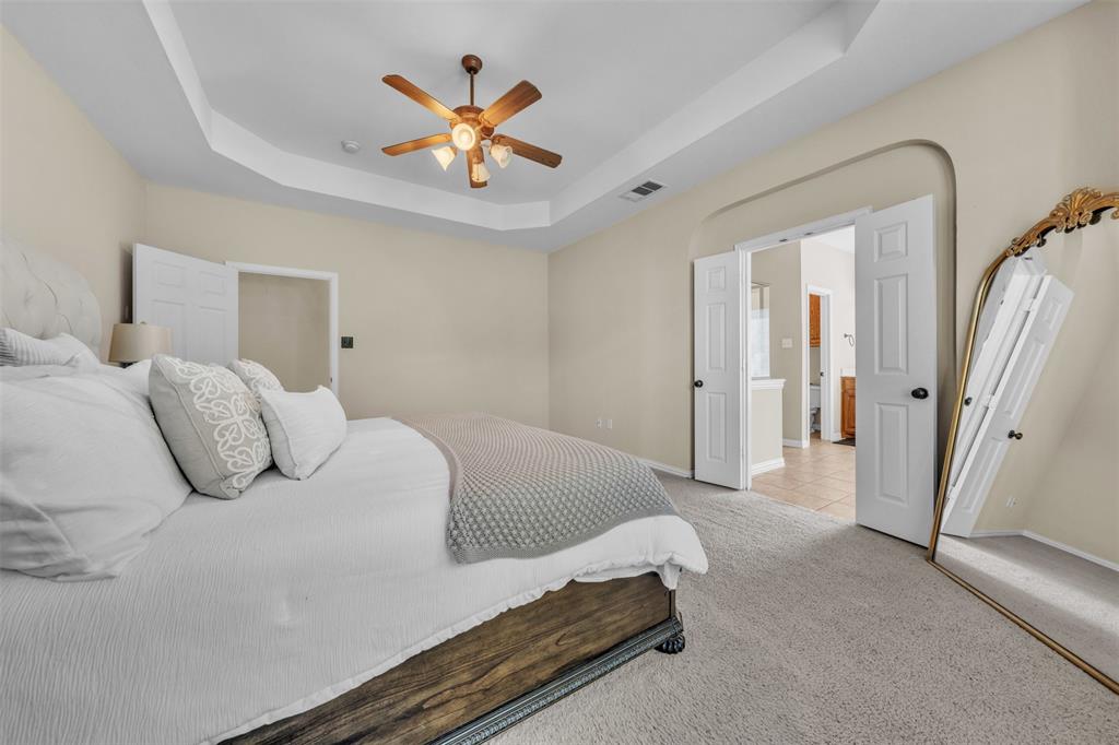 437 Rusty Run Drive Midlothian, TX 76065 - Photo 20 of 40 a bedroom with a large bed and a chandelier