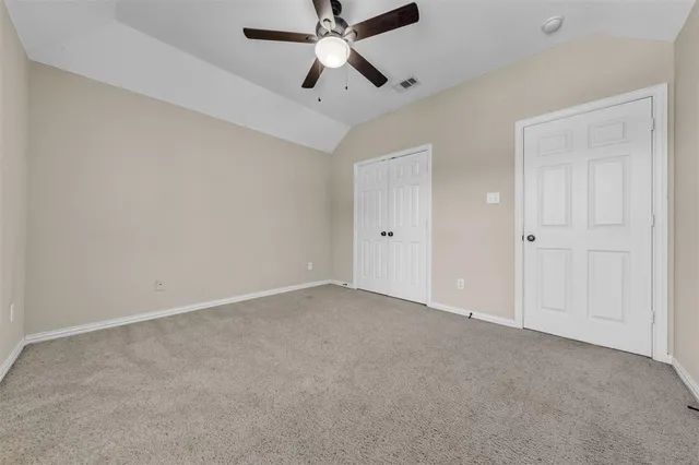 an empty room with chandelier fan
