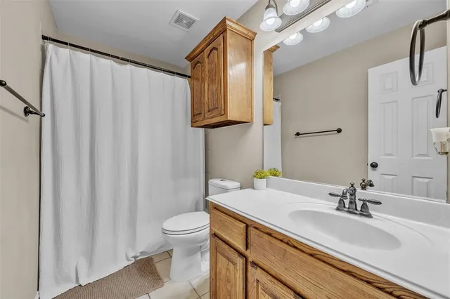 a bathroom with a sink a toilet and shower curtain