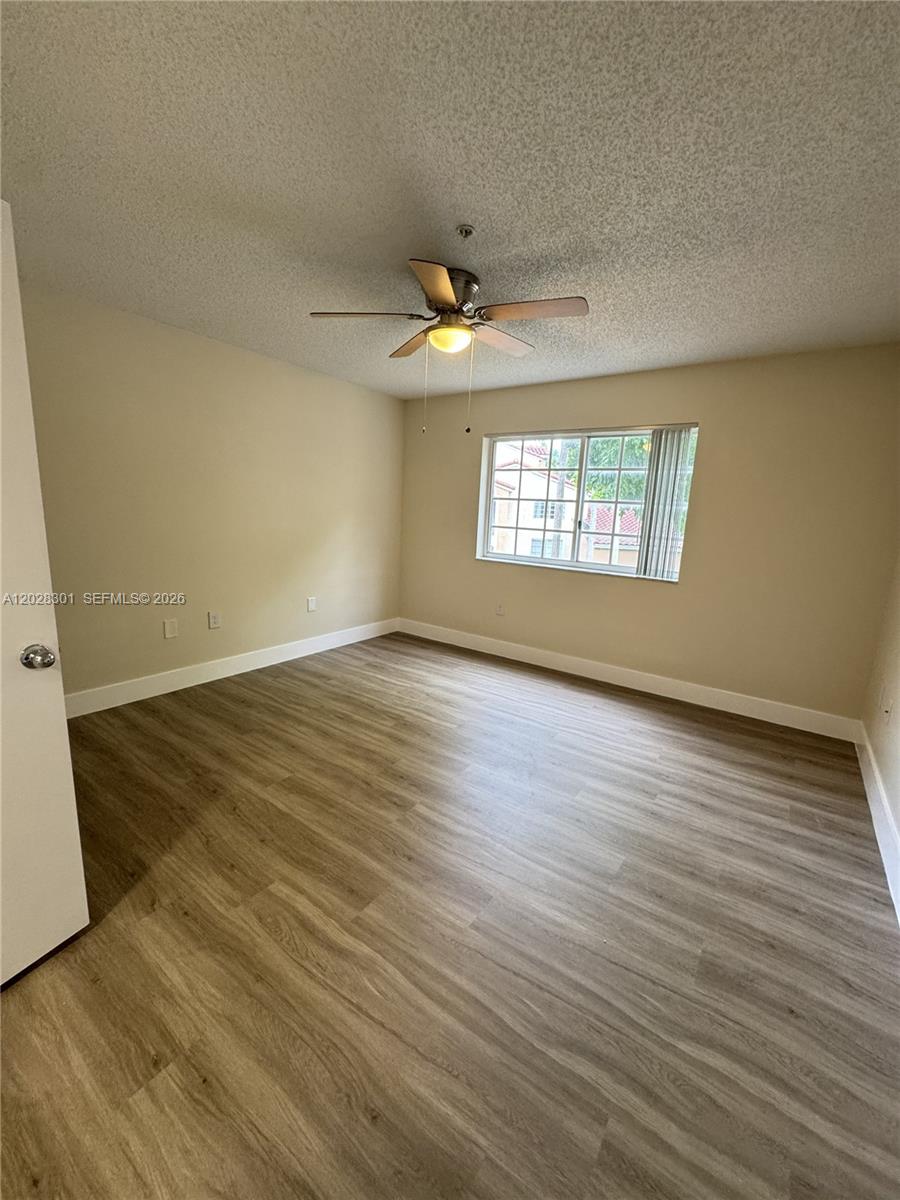 2021 Renaissance Boulevard, Unit 201 Miramar, FL 33025 - Photo 15 of 26 an empty room with wooden floor and windows