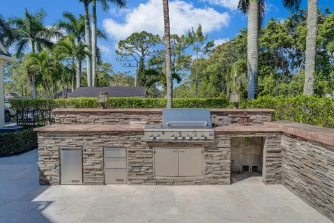 a kitchen with stainless steel appliances kitchen island granite countertop a refrigerator and a stove top oven