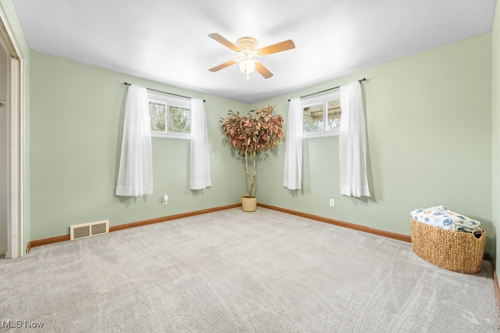 4551 17th Street Northwest Canton, OH 44708 - Photo 26 of 39 Carpeted empty room featuring a healthy amount of sunlight, baseboards, visible vents, and a ceiling fan