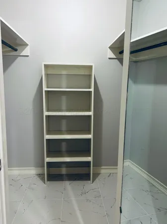 a view of walk in closet with empty racks