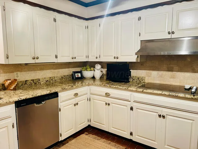a kitchen with granite countertop white cabinets and white appliances