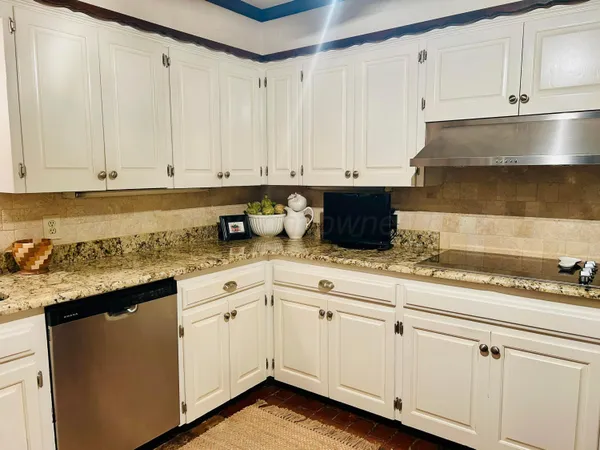 a kitchen with granite countertop white cabinets and white appliances