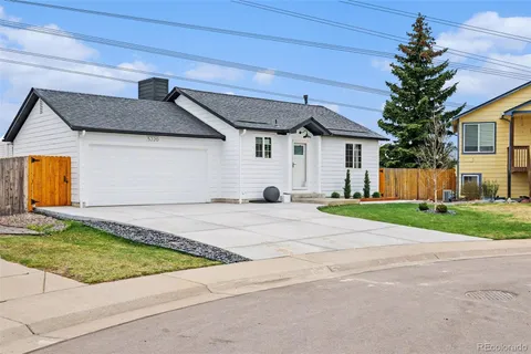a view of a white house with a yard and garage