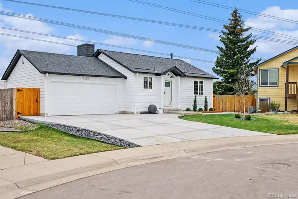 a view of a white house with a yard and garage