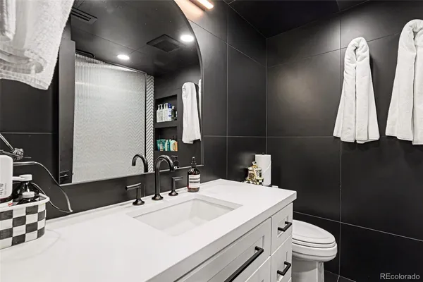 a bathroom with a sink a toilet and a mirror