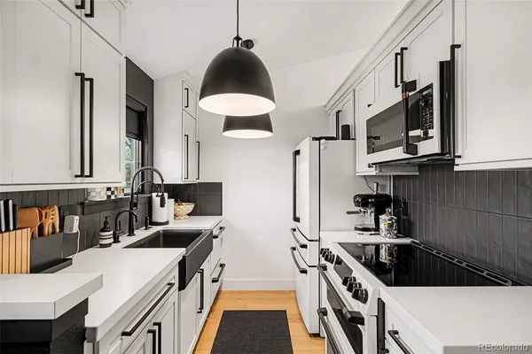 a kitchen with stainless steel appliances a stove a sink and a refrigerator