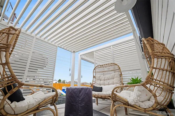 a view of a patio with chair and table and chairs and wooden fence