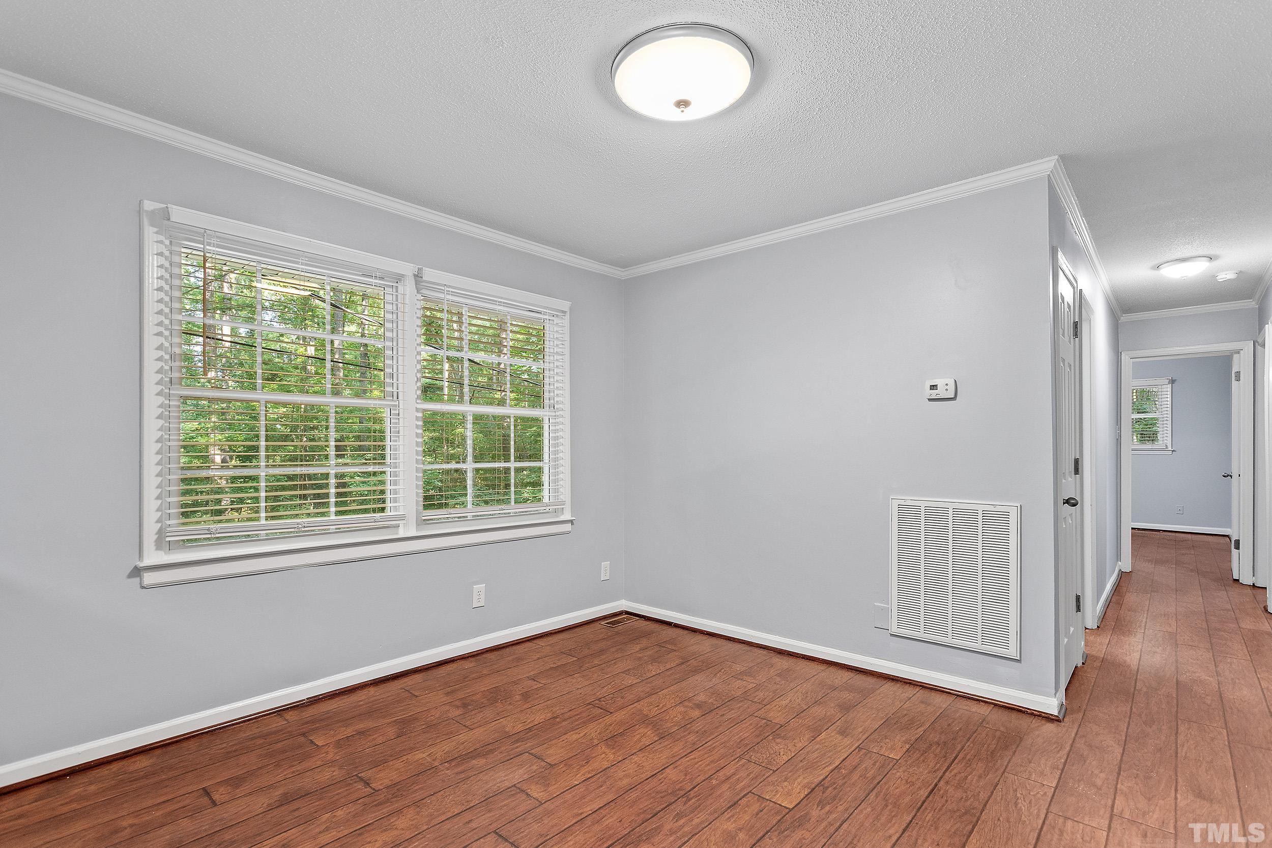 2921 Darrow Road Durham, NC 27704 - Photo 15 of 32 a view of an empty room with wooden floor and a window