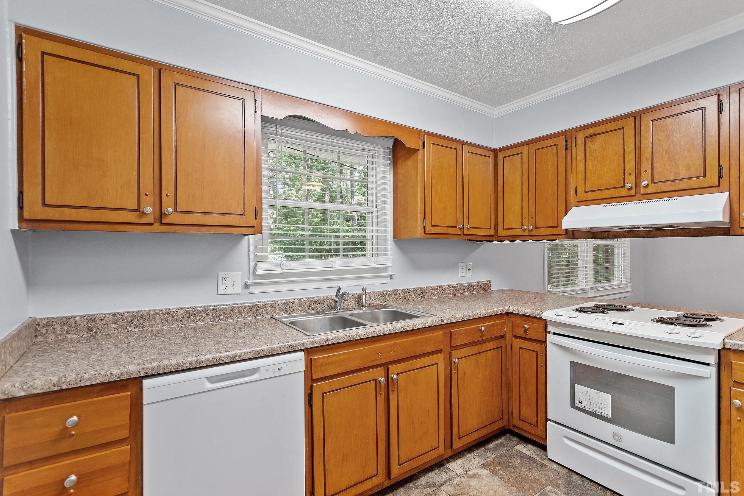 2921 Darrow Road Durham, NC 27704 - Photo 18 of 32 a kitchen with granite countertop cabinets stainless steel appliances a sink and window