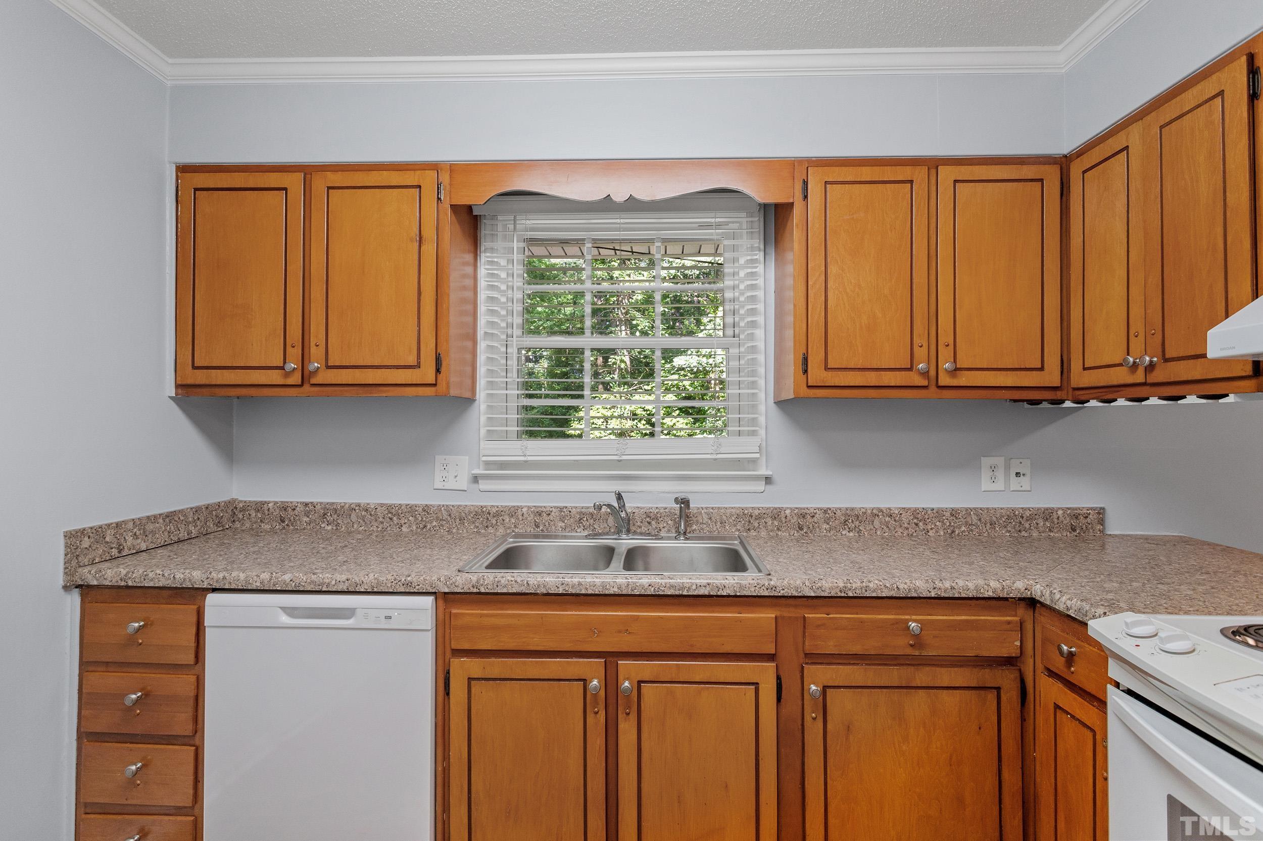 2921 Darrow Road Durham, NC 27704 - Photo 19 of 32 a kitchen with stainless steel appliances granite countertop cabinets and a window