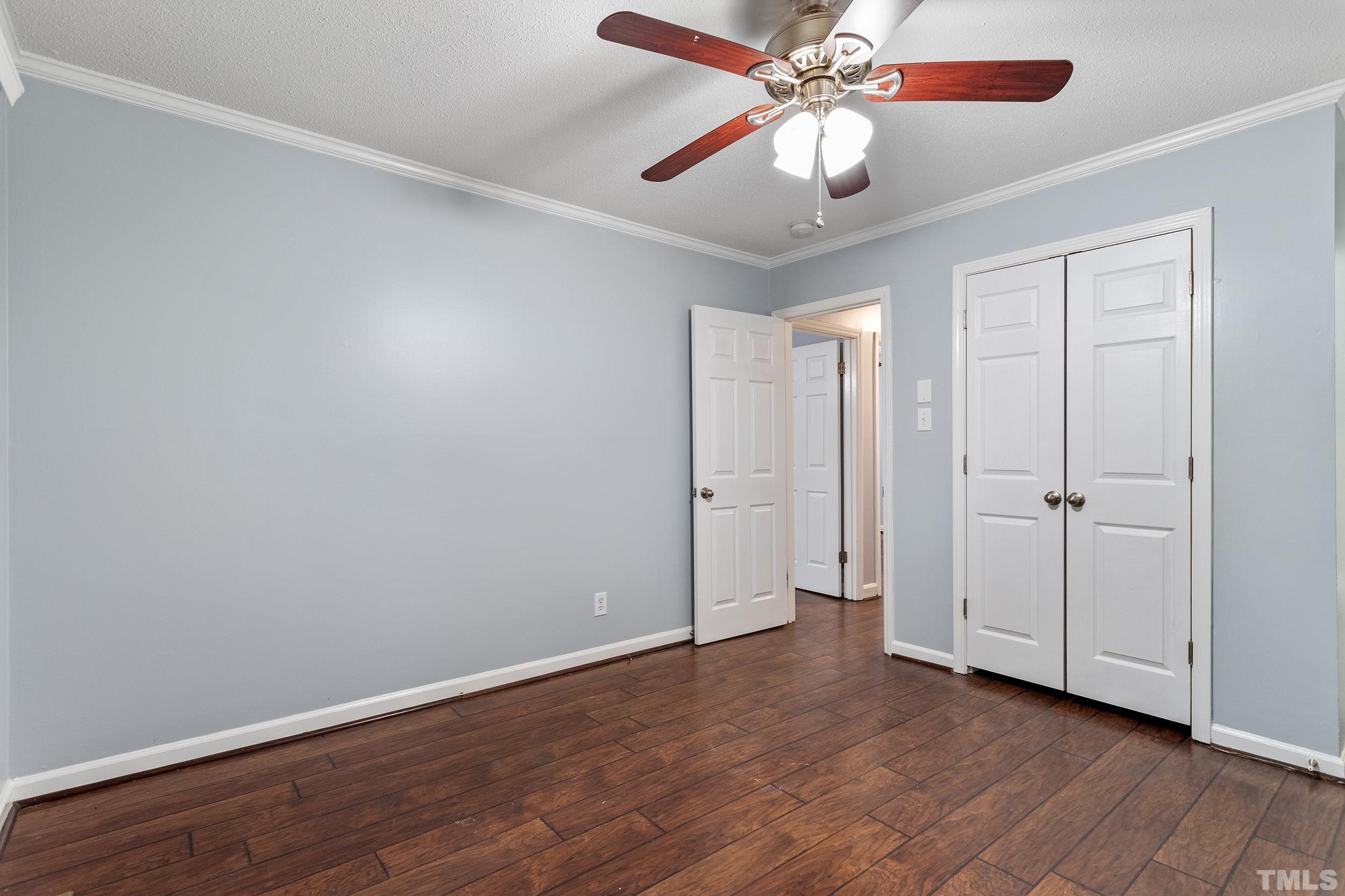 2921 Darrow Road Durham, NC 27704 - Photo 23 of 32 an empty room with wooden floor closet fan and windows