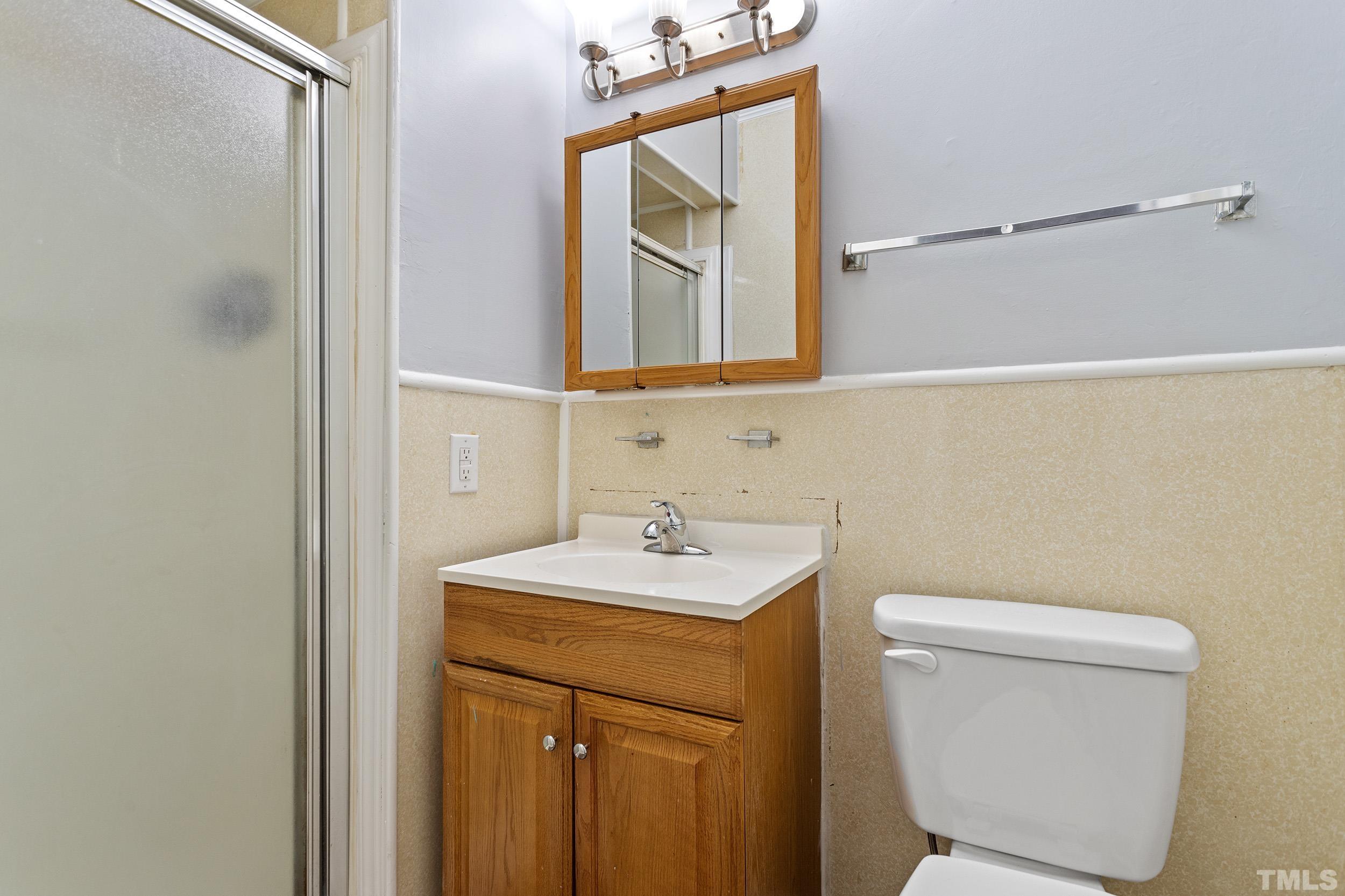 2921 Darrow Road Durham, NC 27704 - Photo 25 of 32 a bathroom with a toilet sink and mirror