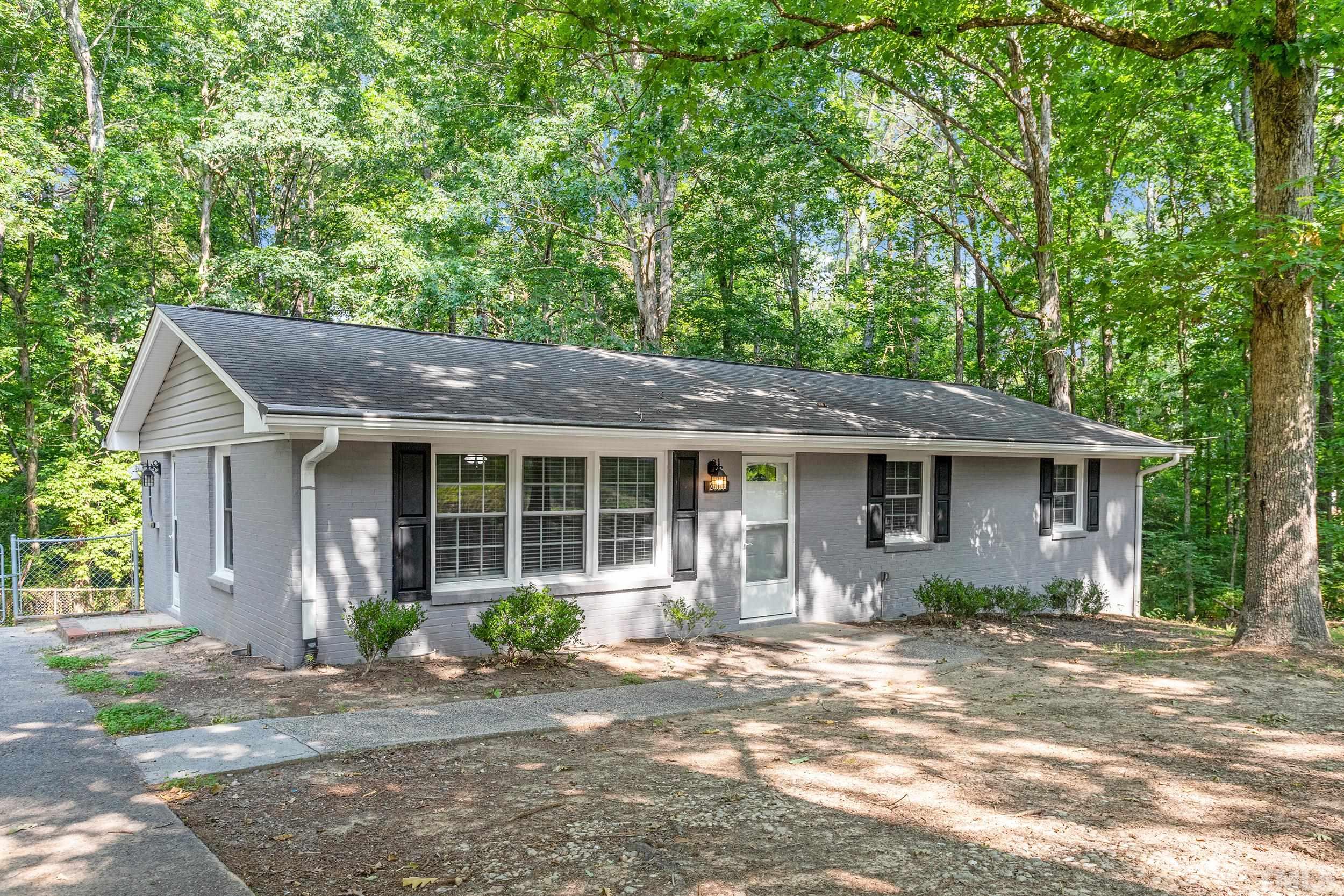 2921 Darrow Road Durham, NC 27704 - Photo 3 of 32 a front view of a house with a garden and plants