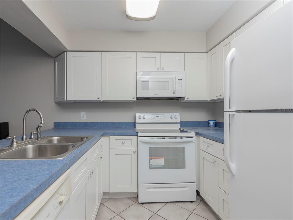4356 Southwest 20th Lane Gainesville, FL 32607 - Photo 7 of 15 a kitchen with white cabinets appliances and sink