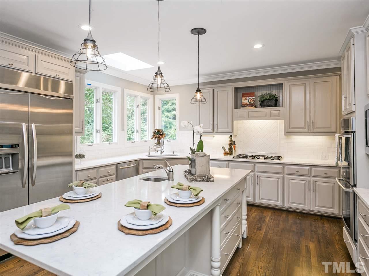4038 John S Raboteau Wynd Raleigh, NC 27612 - Photo 7 of 25 a kitchen with stainless steel appliances granite countertop a white cabinets and couches
