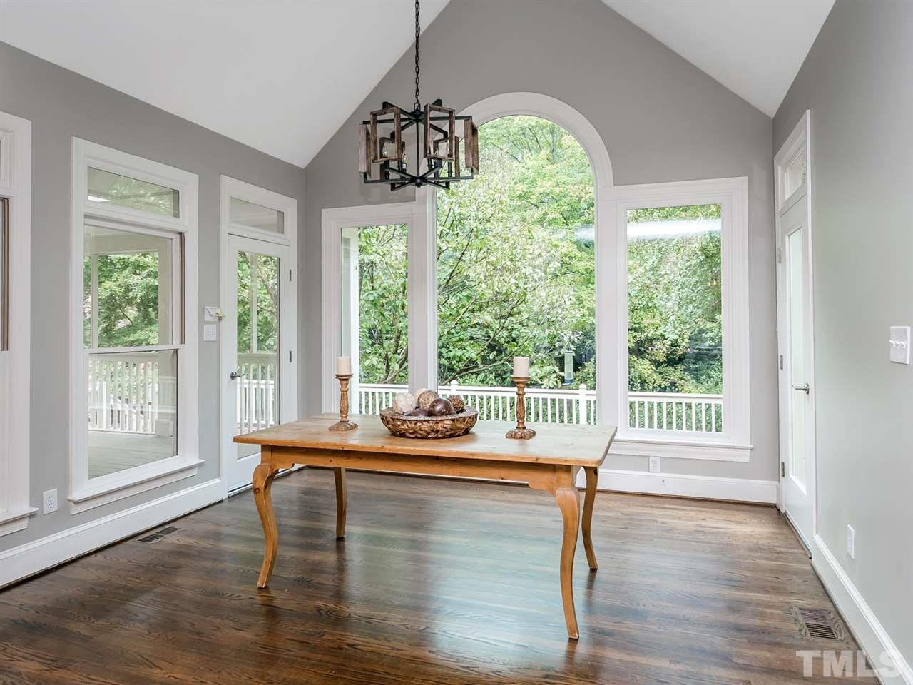 4038 John S Raboteau Wynd Raleigh, NC 27612 - Photo 10 of 25 a dining room with wooden floor a chandelier a potted plant and windows