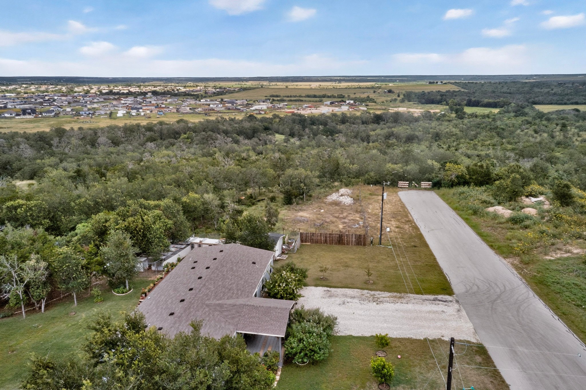 693 Santa Teresa Road Kyle, TX 78640 - Photo 11 of 20 An aerial perspective reveals a serene residential area nestled amongst abundant greenery, offering a peaceful suburban escape.