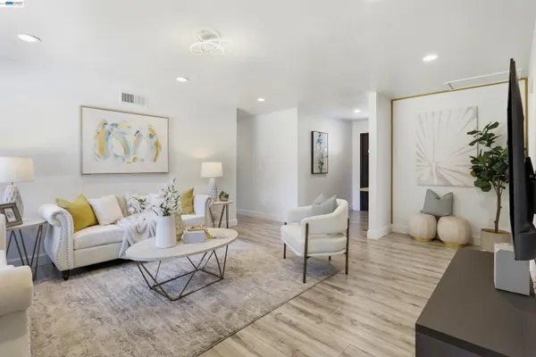 a living room with furniture and wooden floor